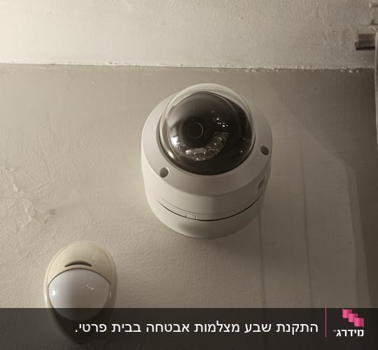 מצלמת אבטחה עגולה על תקרה לבנה